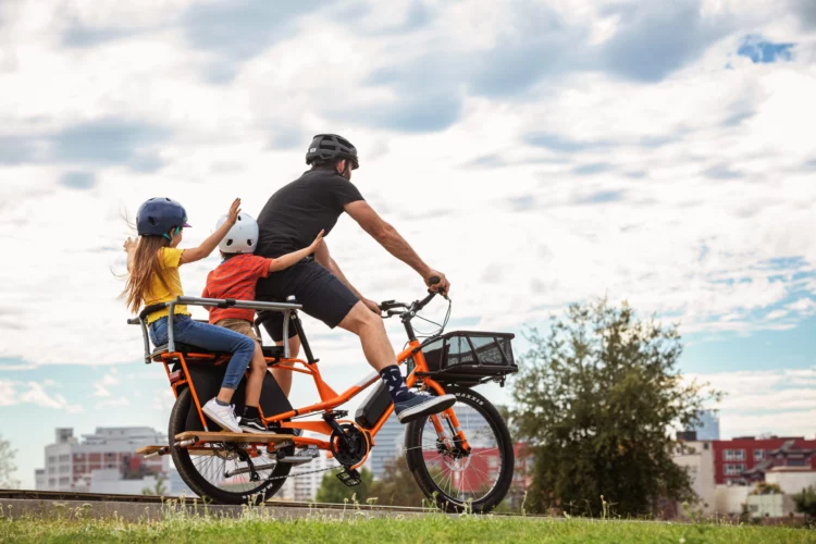 Yuba_Bikes_KombiE5_Orange_Bread_Basket_Monkey_Bars_Two_Kids-scaled-1 carry kids on bikes a family friendly cargo bike designed to carry 2 children safely
